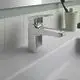 Moderne Waschtischarmatur von Ideal Standard mit glänzender Oberfläche, montiert auf einem weißen Waschbecken, neben einem Becher für Zahnbürsten.
